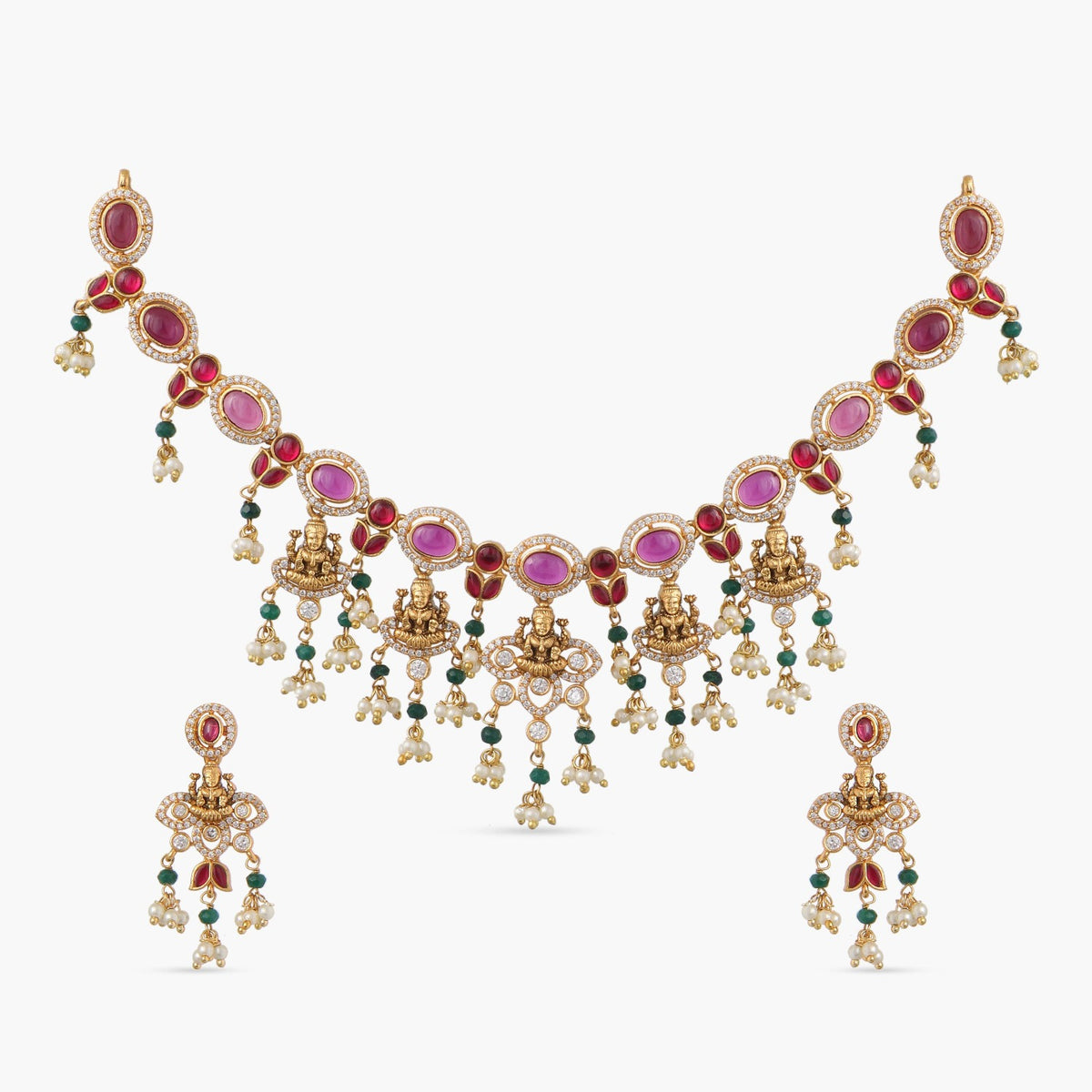 A picture of Indian artificial jewelry. It is a necklace and earring set with pink and green gemstones.